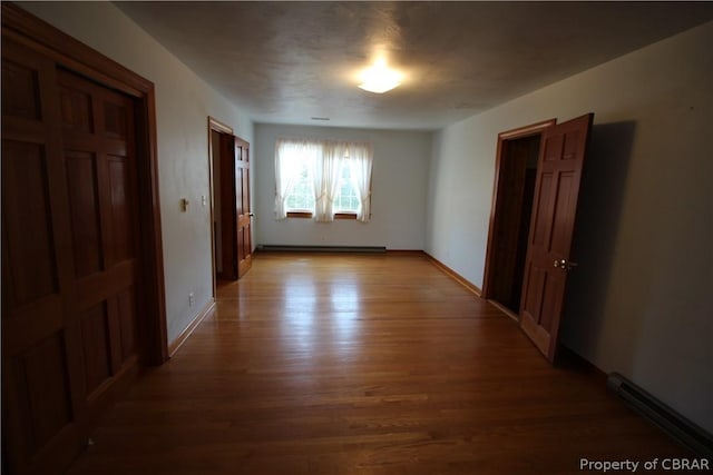 interior space with light wood-type flooring, baseboards, and baseboard heating