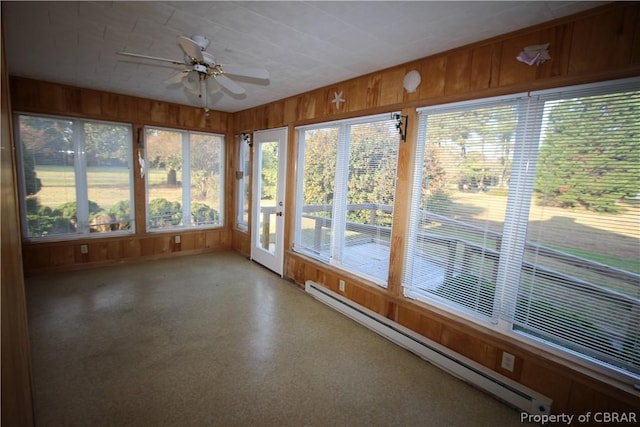 unfurnished sunroom with a baseboard heating unit and a ceiling fan