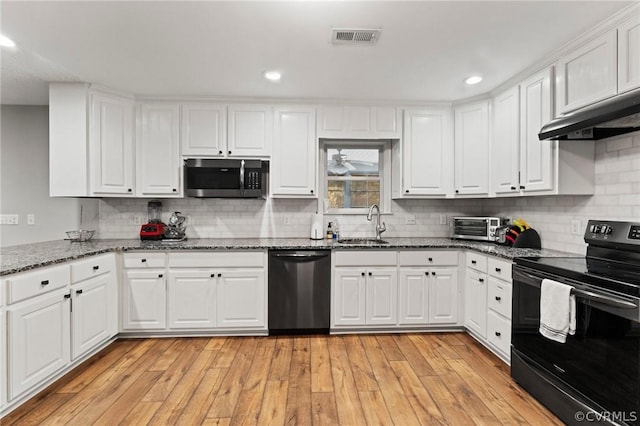 kitchen featuring appliances with stainless steel finishes, light wood-type flooring, and white cabinetry