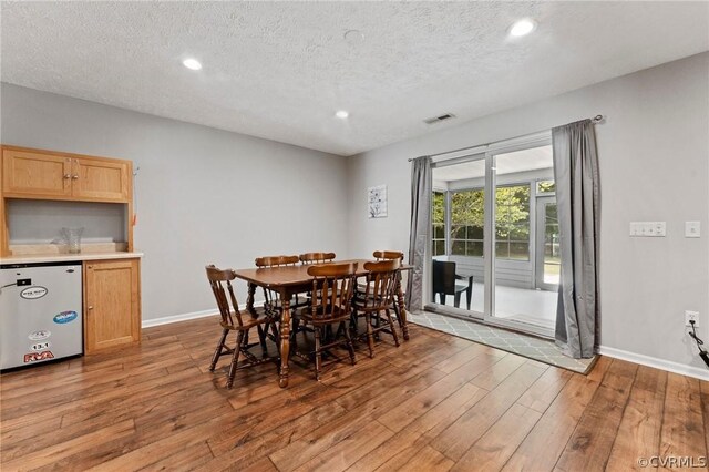 dining room with a textured ceiling and hardwood / wood-style flooring