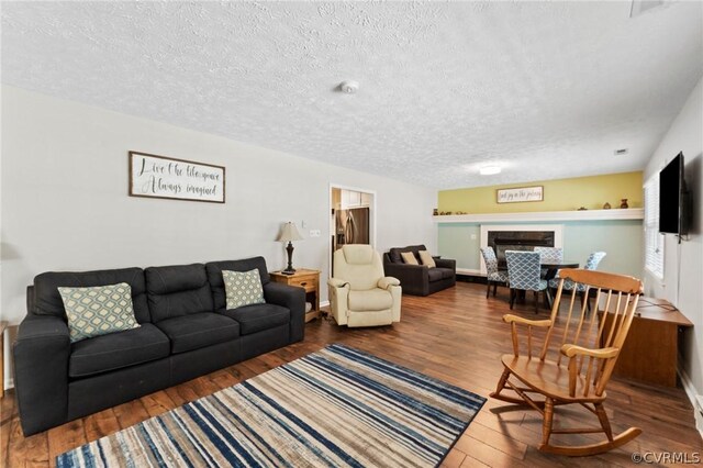 living room featuring a textured ceiling and dark wood-type flooring