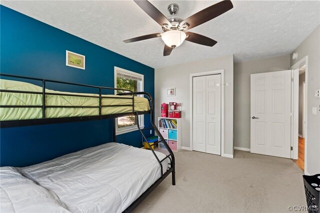 bedroom featuring carpet floors, a textured ceiling, ceiling fan, and a closet