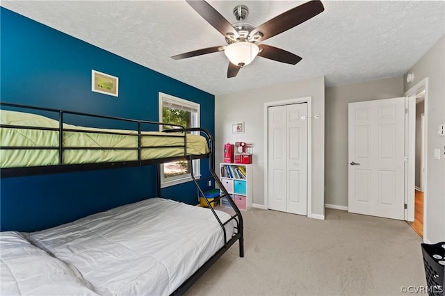 bedroom featuring ceiling fan, carpet, a textured ceiling, and a closet