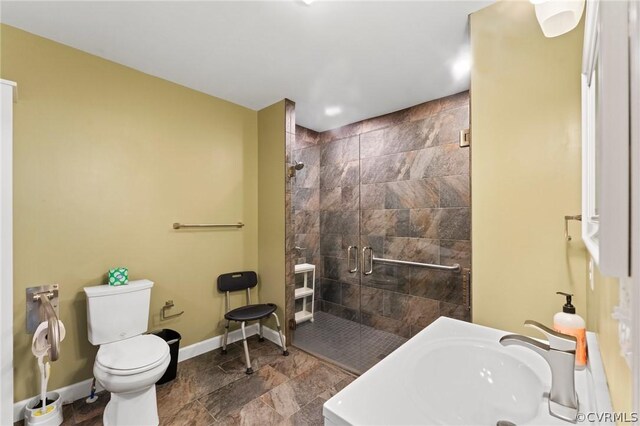 bathroom with tiled shower, tile patterned floors, toilet, and sink