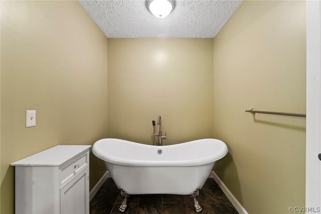 bathroom with a textured ceiling and a washtub