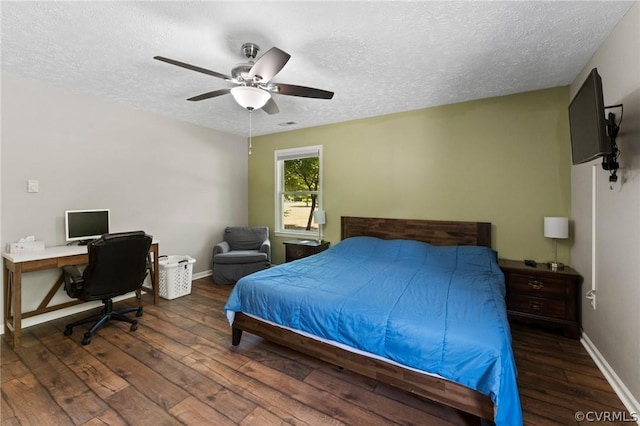 bedroom with dark hardwood / wood-style flooring, ceiling fan, and a textured ceiling