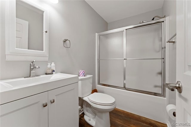 full bathroom with vanity, toilet, wood-type flooring, and shower / bath combination with glass door