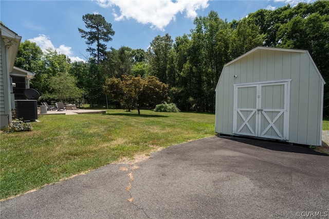 exterior space with cooling unit, a patio area, and a shed