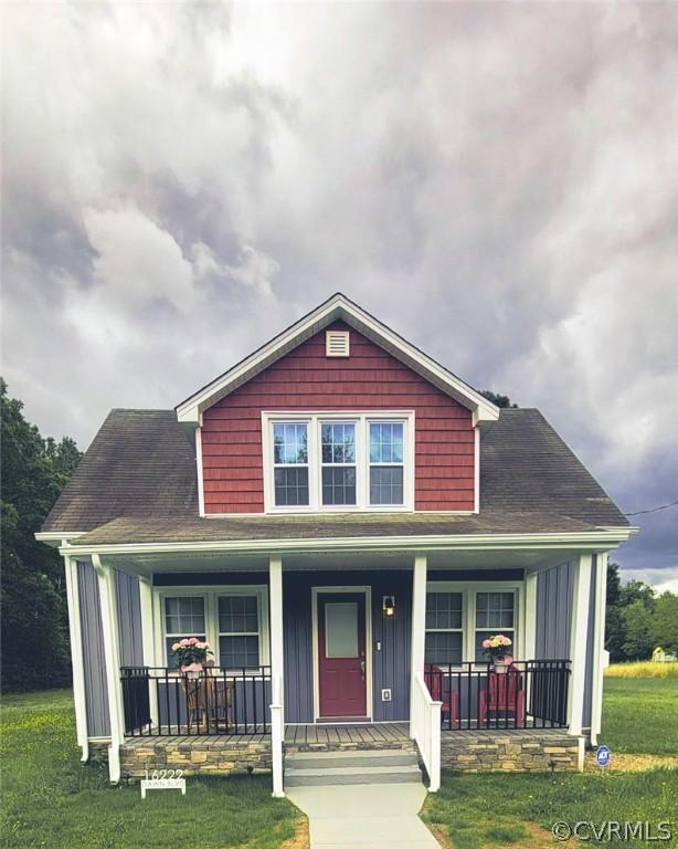 view of front of home featuring covered porch and a front yard