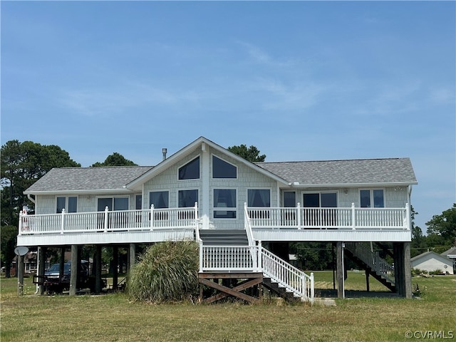 back of house featuring stairway, a yard, and roof with shingles