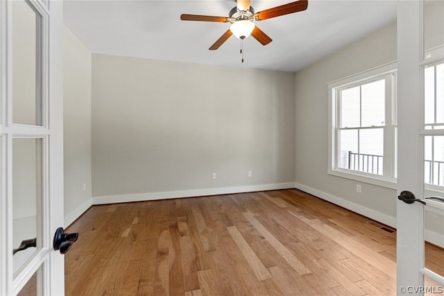 empty room with ceiling fan, french doors, baseboards, and light wood-style floors