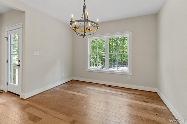 empty room with plenty of natural light, baseboards, and hardwood / wood-style floors