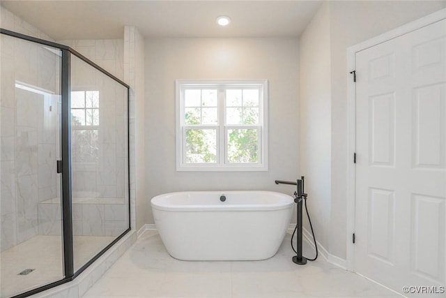 bathroom featuring a soaking tub, baseboards, marble finish floor, and a shower stall