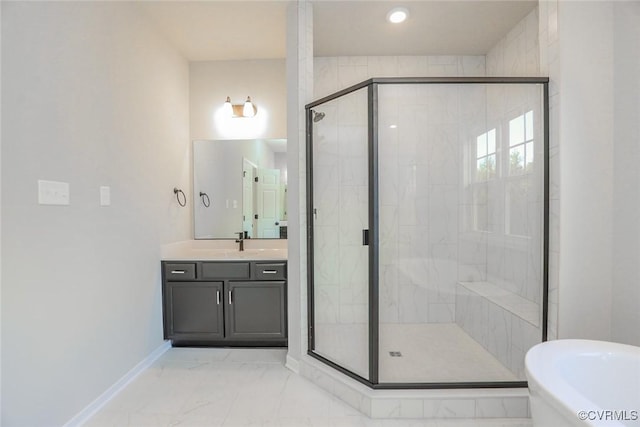 full bathroom featuring marble finish floor, a stall shower, baseboards, a freestanding bath, and vanity