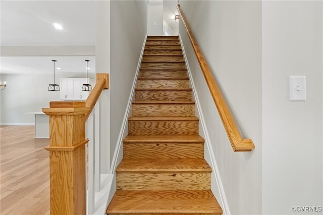 staircase featuring recessed lighting, baseboards, and wood finished floors