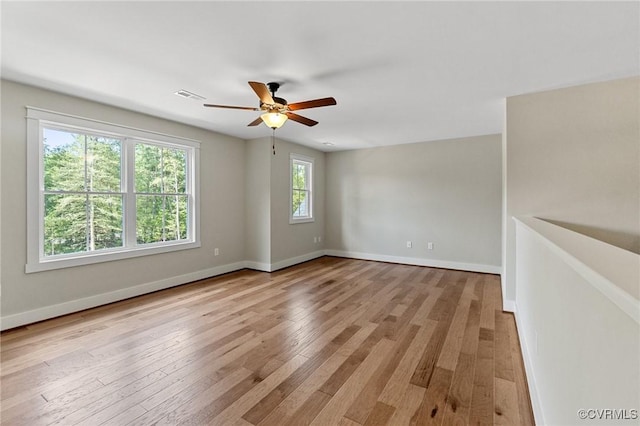 empty room with visible vents, wood-type flooring, and baseboards