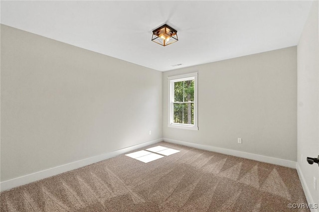 carpeted empty room featuring baseboards