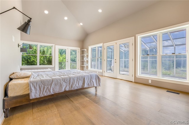 bedroom with access to exterior, high vaulted ceiling, french doors, and light wood-type flooring