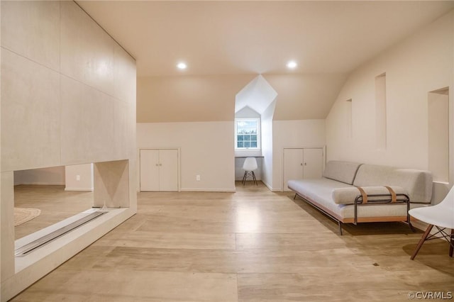 unfurnished room featuring recessed lighting, lofted ceiling, and light wood-style floors