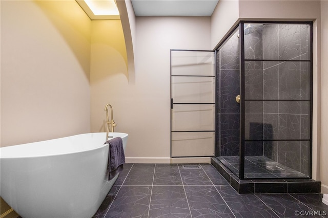 bathroom with separate shower and tub and tile patterned flooring