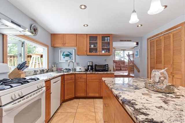 kitchen featuring pendant lighting, dishwasher, light stone countertops, and white range with gas stovetop