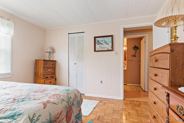 bedroom with a closet, light parquet floors, and ornamental molding