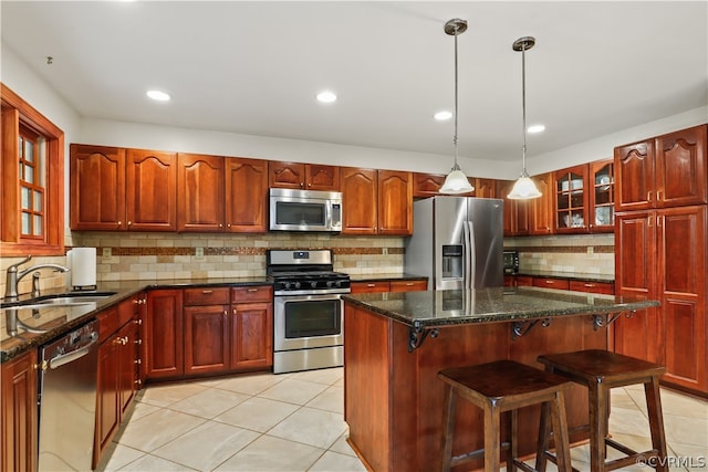 kitchen with decorative backsplash, a kitchen breakfast bar, sink, light tile patterned flooring, and stainless steel appliances