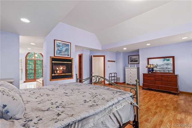 bedroom featuring vaulted ceiling and light hardwood / wood-style flooring