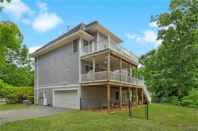 back of property featuring a garage, a deck, and a lawn