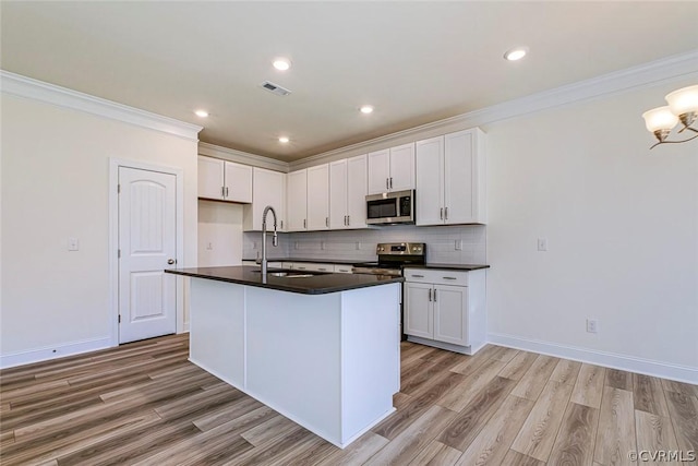 kitchen featuring white cabinetry, stainless steel appliances, sink, and a kitchen island with sink