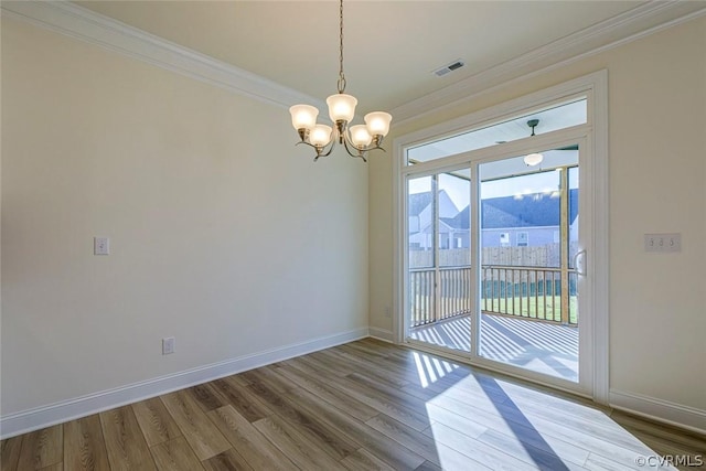 unfurnished dining area featuring wood-type flooring, a mountain view, ornamental molding, and a chandelier