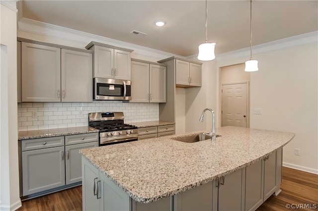 kitchen with stainless steel appliances, light stone countertops, and sink