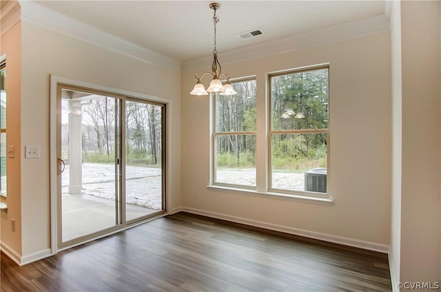 unfurnished dining area with crown molding, an inviting chandelier, and dark hardwood / wood-style flooring