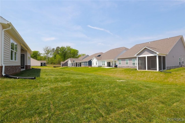 view of grassy yard with a sunroom
