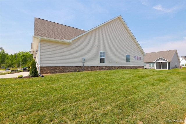 view of property exterior with a yard and a shingled roof