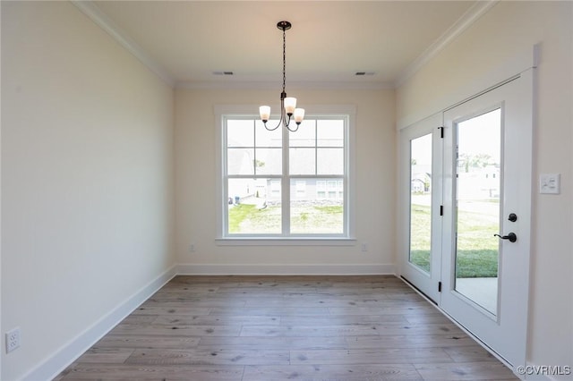 unfurnished dining area with crown molding, a chandelier, light wood-type flooring, and baseboards
