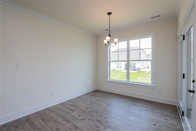 unfurnished room with a chandelier, baseboards, crown molding, and wood finished floors