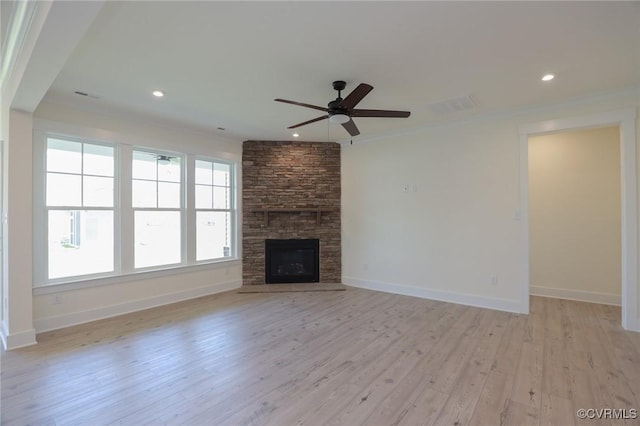 unfurnished living room with a ceiling fan, light wood-style floors, baseboards, crown molding, and a fireplace