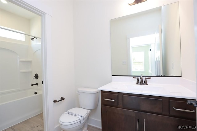 bathroom with toilet, wood finished floors, vanity, shower / bathtub combination, and plenty of natural light