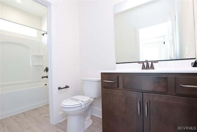 full bath with toilet, wood finished floors, vanity, and shower / bath combination