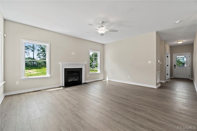 unfurnished living room with hardwood / wood-style flooring, plenty of natural light, and ceiling fan