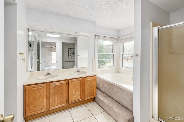 bathroom featuring tile patterned flooring, vanity, a textured ceiling, and plus walk in shower