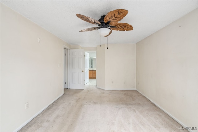 empty room with light carpet, ceiling fan, and a textured ceiling