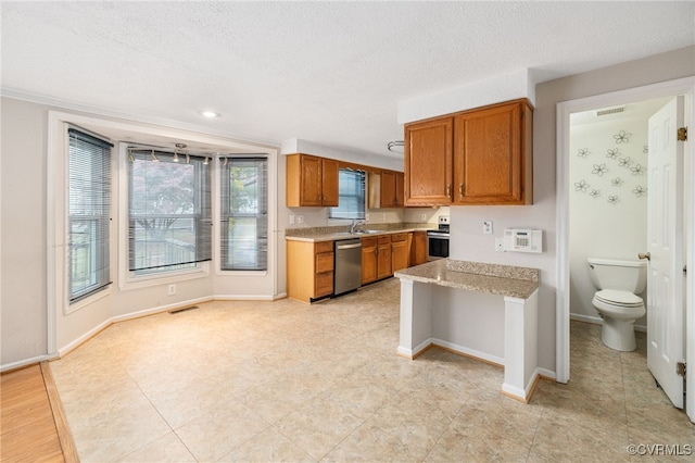 kitchen with sink, a textured ceiling, and appliances with stainless steel finishes