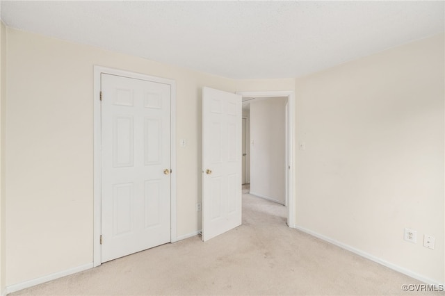 unfurnished bedroom featuring light carpet