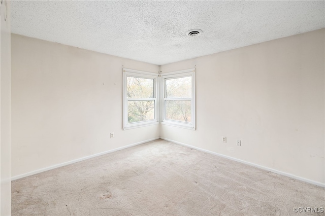 carpeted spare room with a textured ceiling