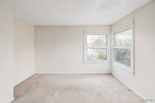 carpeted empty room with a textured ceiling