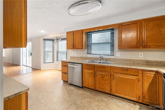 kitchen featuring dishwasher, a textured ceiling, ornamental molding, and sink