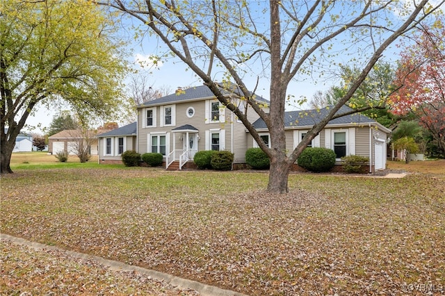 colonial-style house with a front yard and a garage