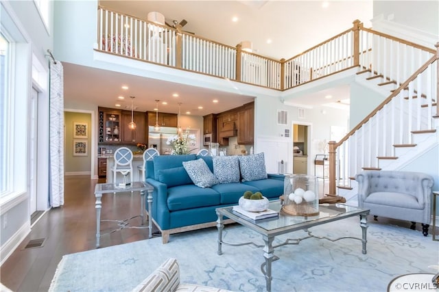 living room with a towering ceiling and dark hardwood / wood-style floors